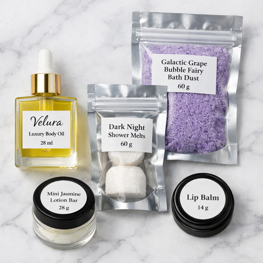 Lavish 4 Less flat‑lay of Velura body oil, bath dust, shower melts, lotion bar, and lip balm on marble.