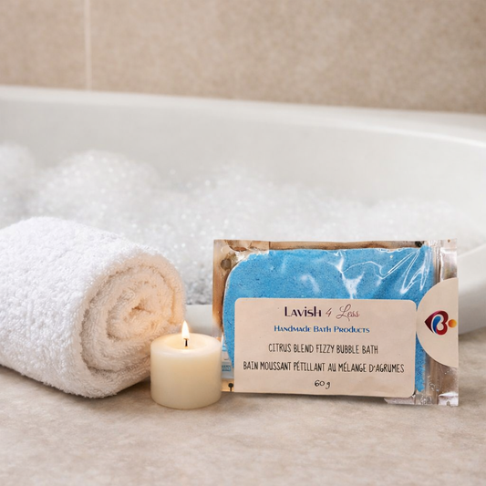 Lavish 4 Less Citrus Blend Fizzy Bubble Bath displayed beside a rolled white towel and candle near a bubble‑filled tub, handmade bath products in Barrie Ontario.