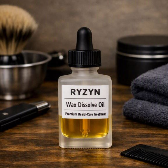   
RYZYN Wax Dissolve Oil — frosted rectangular 28 ml bottle with golden beard‑care oil and white label reading “Premium Beard‑Care Treatment,” placed mid‑scene on a dark wooden grooming surface surrounded by a shaving bowl, brush, razor, towel, and matte tin.