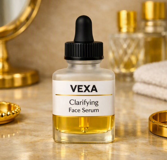 rosted 28 ml glass dropper bottle labeled “VEXA Clarifying Face Serum” with a subtle gold accent line, sitting naturally on a beige marble vanity surrounded by gold accessories, mirror, and towel under warm, soft lighting.