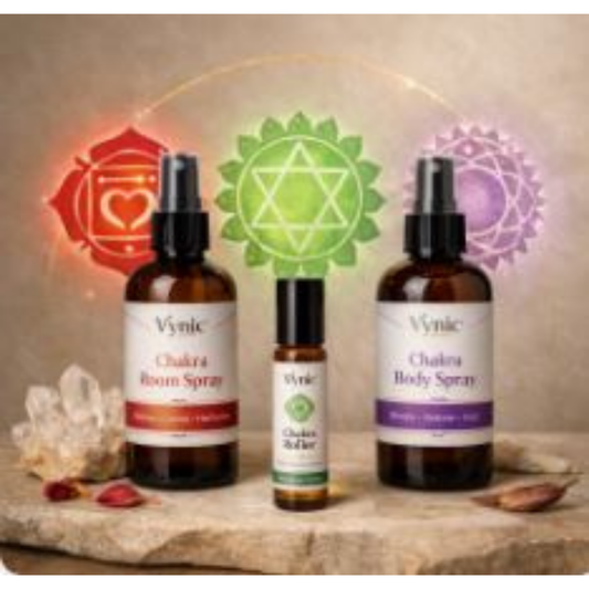 Vynic Chakra Ritual Gift Set displayed in a soft spa‑style scene with body spray, room spray, and roller bottle arranged in a balanced layout. Subtle chakra symbols glow behind the products, with minimal props for a clean, calming aesthetic.